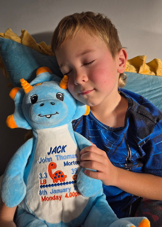 Child holding a blue stuffed dragon toy with personalized details