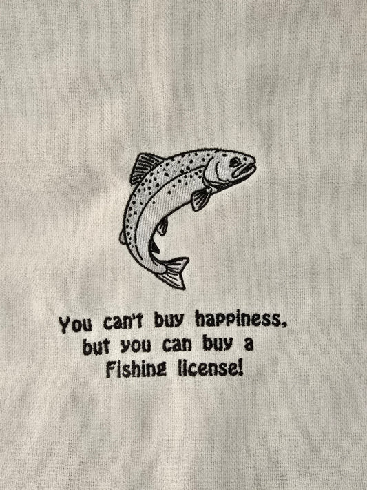 A close-up of a light gray fabric surface with a black line drawing of a jumping fish and the text, 'You can't buy happiness, but you can buy a Fishing license!' printed below it.