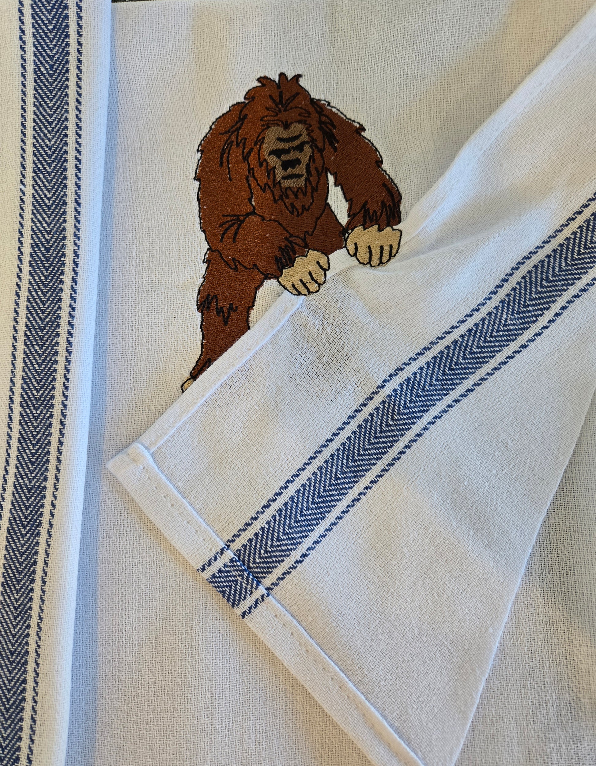 Funny Bigfoot Sasquatch pet thief embroidery design on white cotton striped tea towel NZ